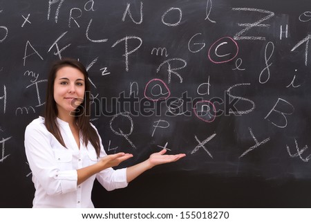 The teacher in the classroom on blackboard background