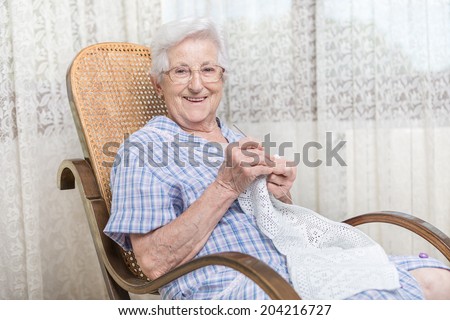 old woman doing crocheting at home, close up