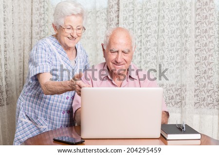 Happy elder couple enjoy together at laptop computer