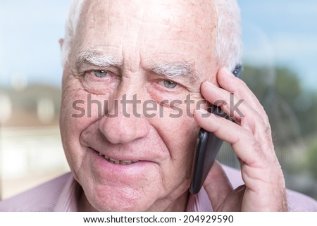 Portrait of an old senior man with a telephone
