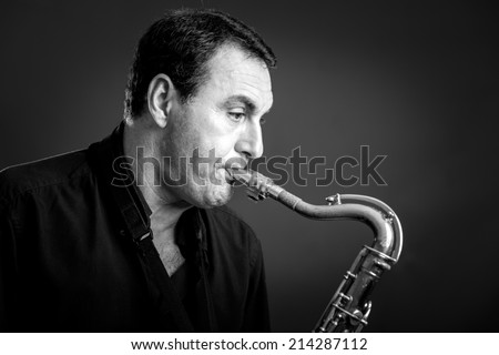 musician playing old saxophone in black and white