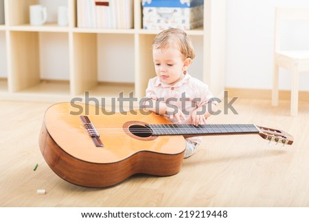Cute little boy playing guitar at the nursery school