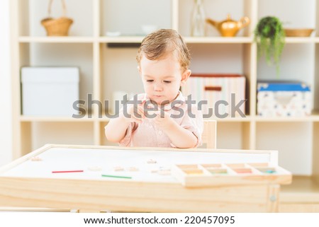 Cute little boy playing with numbers and sticks at the nursery school
