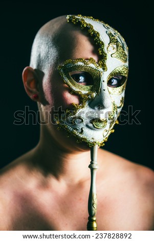 woman in masquerade mask at black background
