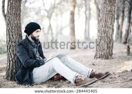 Urban man work on computer at the forest