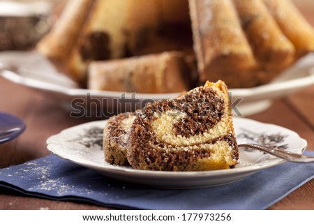 marble ring cake with a castor sugar and a cap of coffee - focus on a piece of cake