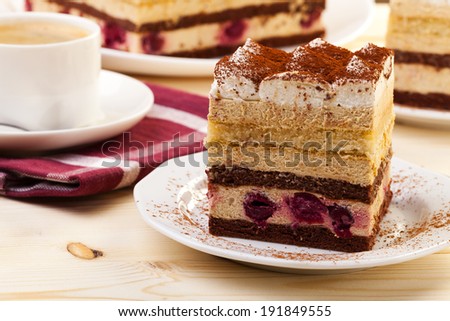 tiramisu cake on plate served with a cap of coffee