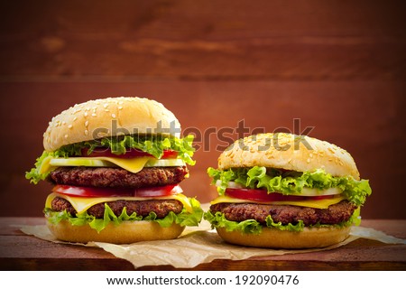 Two hamburgers on wood board