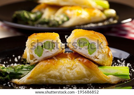 Asparagus baked in puff pastry served on black plate