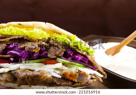 Beef Kebab in a bun with garlic sauce on woodboard
