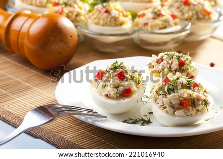stuffed eggs with ham, red pepper and dill on plate