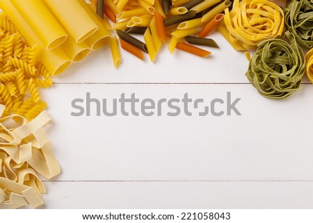 Mix of pasta no white woodboard - background