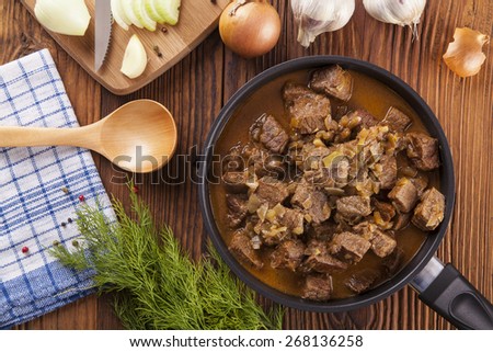 Preparing beef stew - wooden background