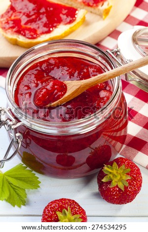 Home made strawberry jam on blue woodboard