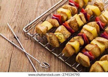 Grilled chicken skewers with pineapple, peppers and onions