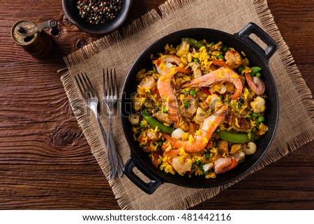 Traditional Spanish paella with seafood and chicken. Prepared in wook. Top view.