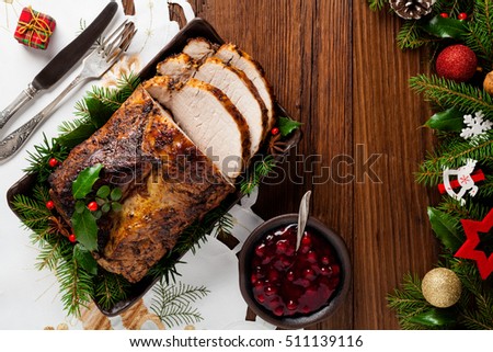 Roast pork loin with Christmas decoration. Top view. Wooden background.