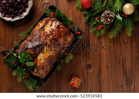 Roast pork loin with Christmas decoration. Top view. Wooden background.