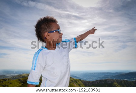 Boy pointing at sky with beautiful landscape