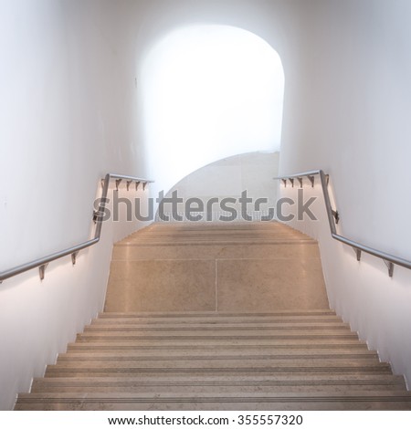 Step Into The Light. Dark stone hallway with a upward staircase leading into the sunlight.