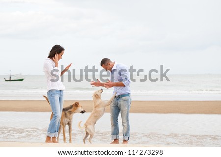 Portrait of a happy couple with dogs at the beach