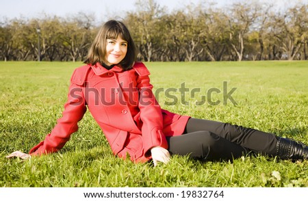 Young Woman Sitting On The Green Grass