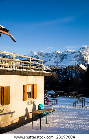 Mountain Restaurant Under The Sunlight. On Of Winter Italian Alps Resort.