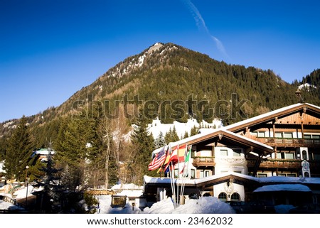 Italian Alps Resort. Different Flags Against Winter Landscape.