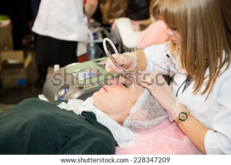 MOSCOW - OCTOBER 24: Cosmetologist applying permanent make up on eyebrows at the international exhibition of professional cosmetics and beauty salon equipment INTERCHARM on October 24, 2014 in Moscow