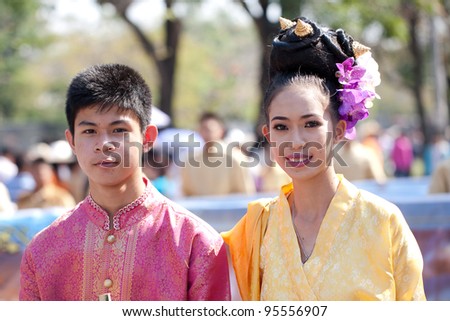 CHIANG MAI, THAILAND - FEBRUARY 4: Traditionally dressed smiling man and woman on Chiang Mai 36th Flower Festival on February 4, 2012 in Chiang Mai, Thailand