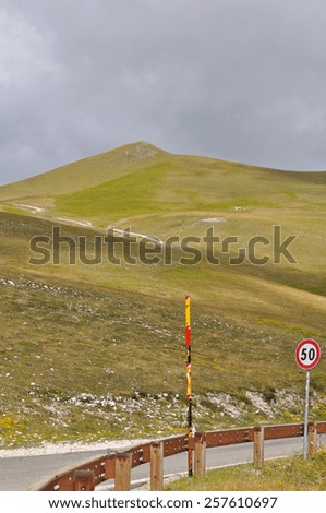 Apennines landscapes, meadows, cloudy sky and road signs of Castelluccio, Umbria,Italy