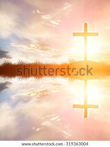 cross silhouette on the mountain at sunset with water reflection