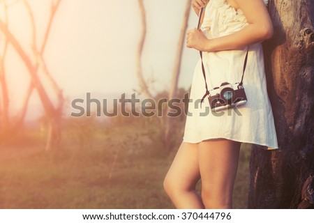Vintage of beautiful women photography standing hand holding retro camera with sunrise