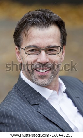 Portrait Of A Businessman With Glasses Smiling Outside