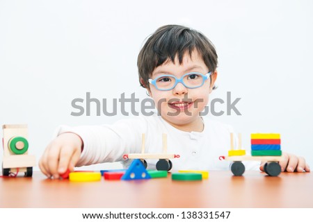 Boy with Down Syndrome playing with wooden train