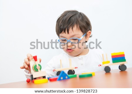 Boy with Down Syndrome playing with wooden train