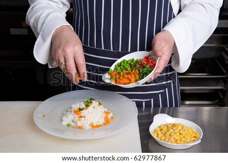 Chef add vegetables to risotto
