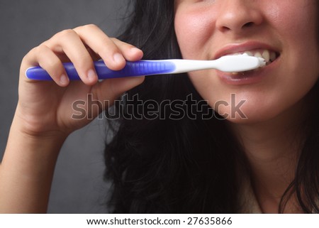 Girl brushing her teeth, with a blue brush