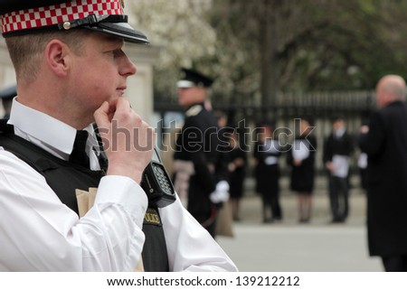LONDON - APRIL 17: A police officer watches the public during the funeral service for Margaret Thatcher at St. Paul\'s Cathedral on April 17, 2013 in London.