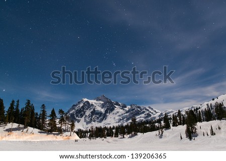 Moon light lights up the Mount Baker and Picture Lake which is covered by thick snow. But still see the stars in the sky.