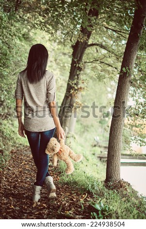 Teddy bear and girl in the woods