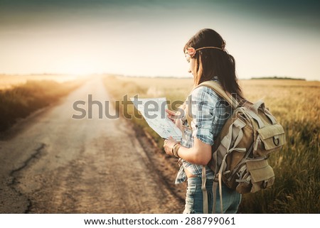 Attractive backpacker girl looking map