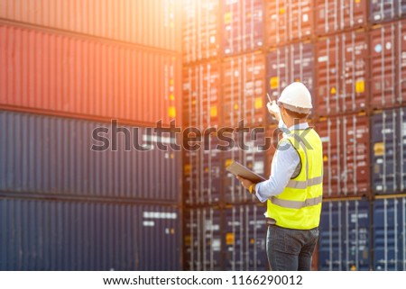 Foreman control loading Containers box from Cargo freight ship for import export.