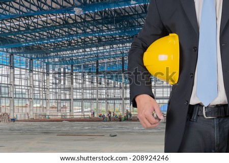 engineer yellow helmet for workers security against the support beams of the unfinished industrial workshop or room inside Copy space for inscription