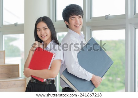 Portrait of students studying in library looking at the viewer with a cheerful smile