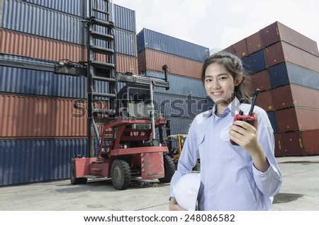 Asian women engineers are talking over the radio in shipping containers