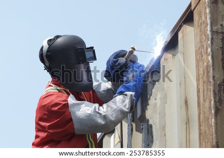 Worker welding the steel part by manual and container box.