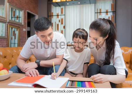 Father man mother helping their children to do their homework in their living room