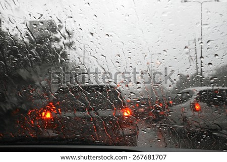 Road view through car window with rain drops, Driving in rain.