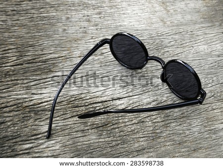 black eye glasses on wood background